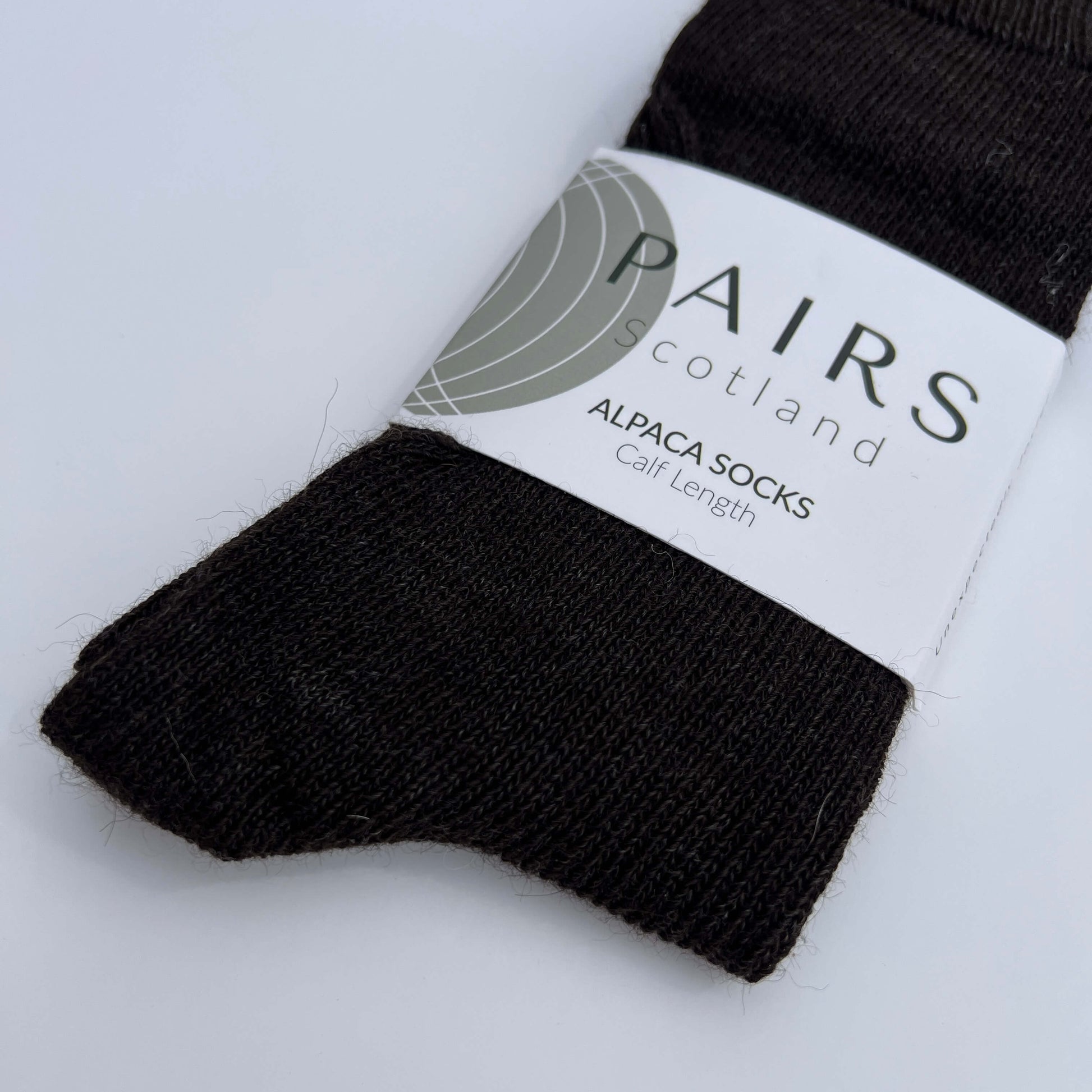 Charcoal undyed alpaca sock with 'PAIRS Scotland' label on a light grey background