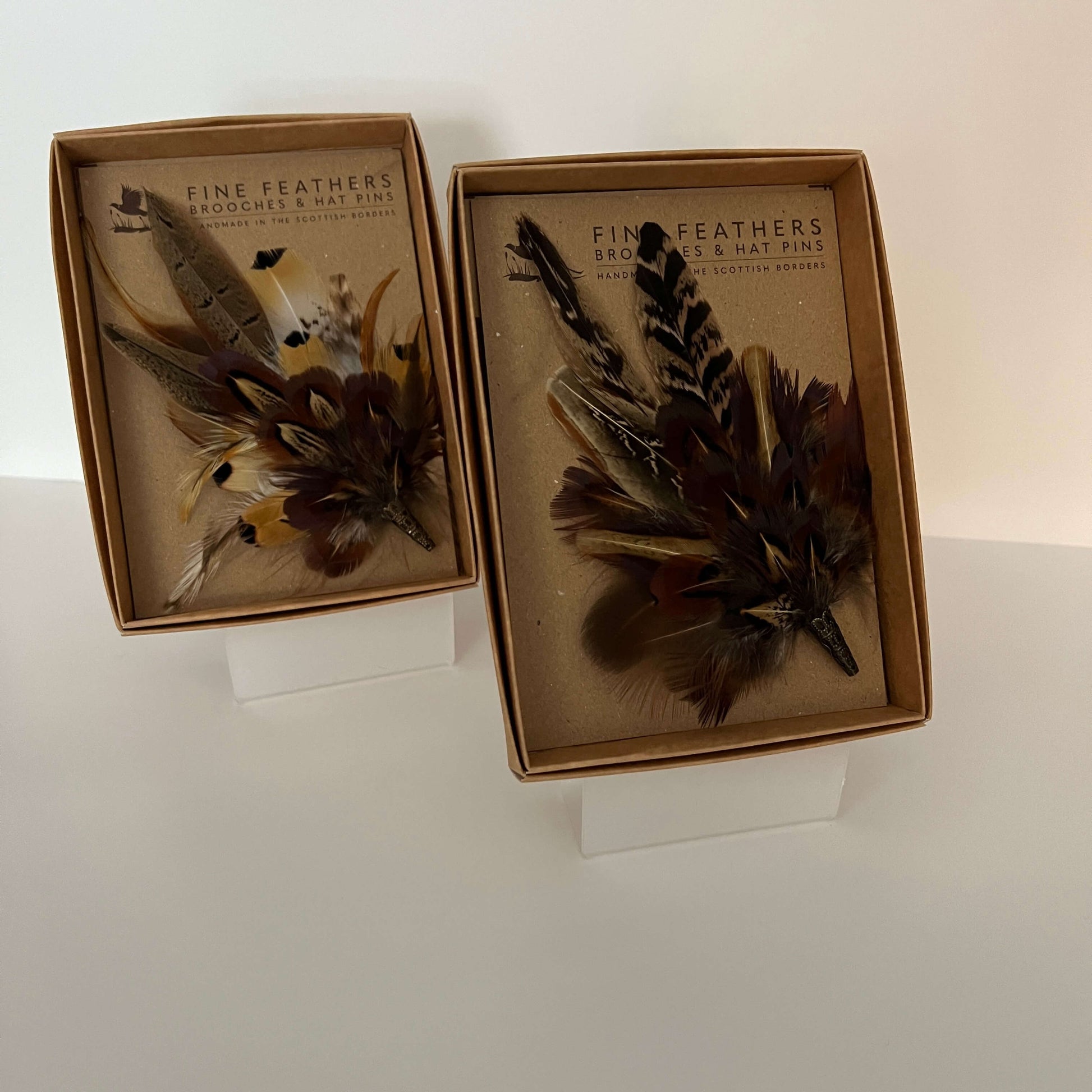 Two boxed pheasant feather brooches by Fine Feathers Design