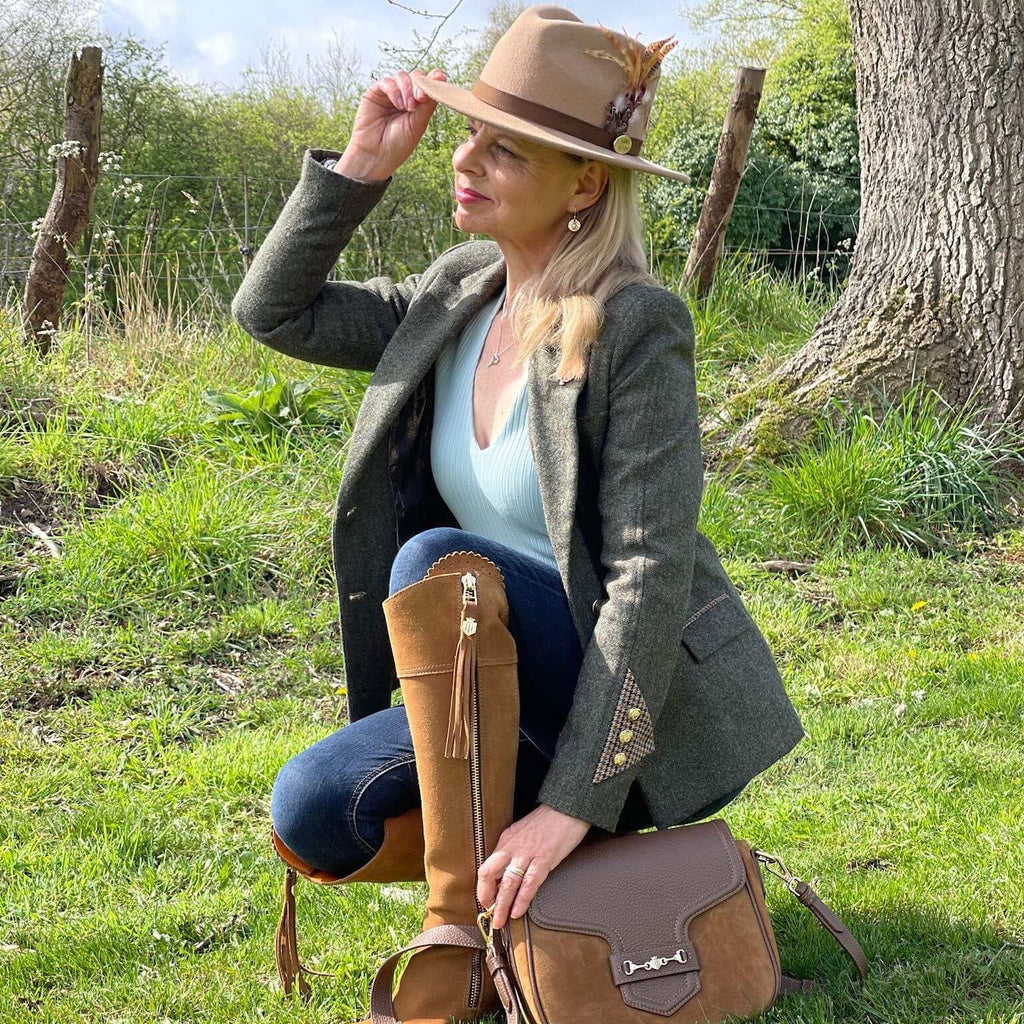 Heyford tweed jacket by English Nettle styled with blue jeans, fawn fedora, feathers and tan boots