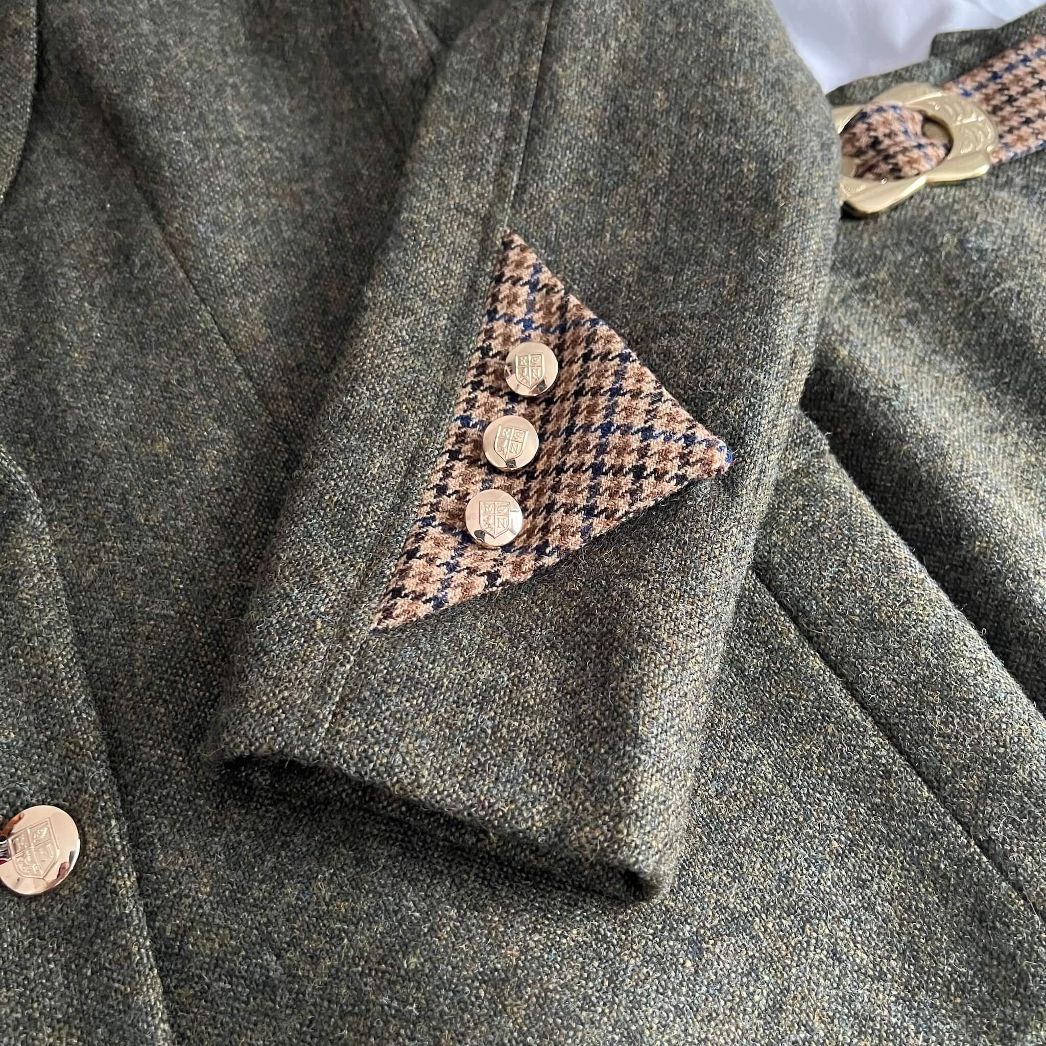 close up of green tweed jacket sleeve cuff detail
