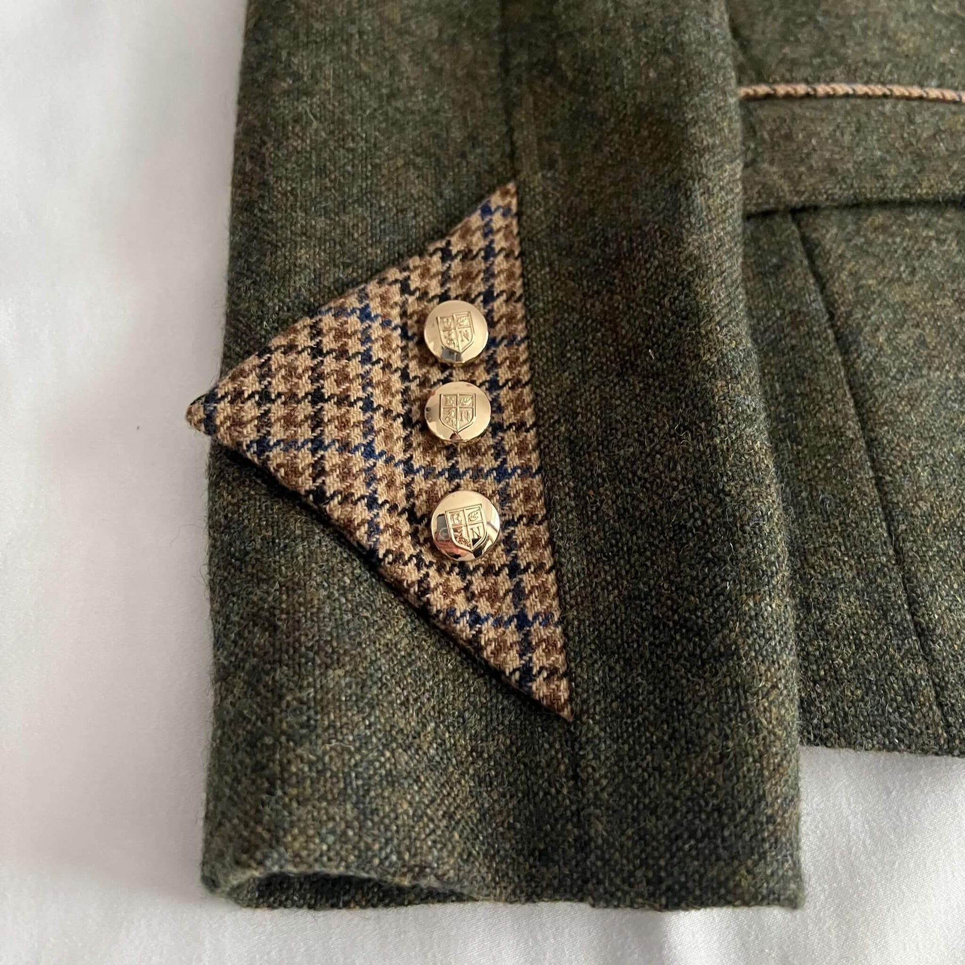 close up of green tweed jacket sleeve cuff detail
