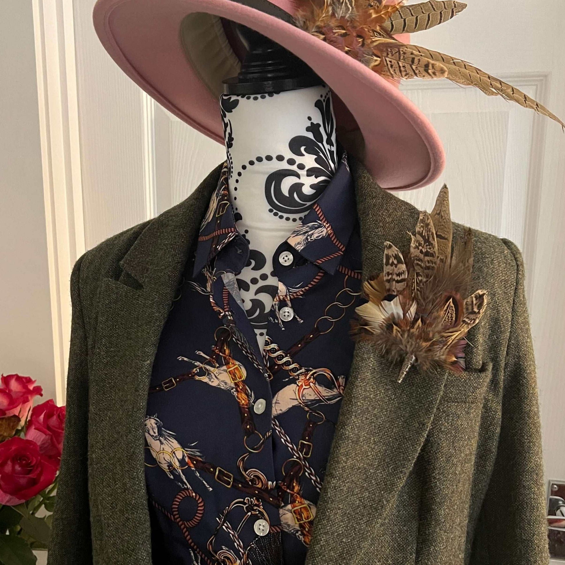 Mannequin dressed for national hunt racing with tweed, feathers, and an equestrian shirt