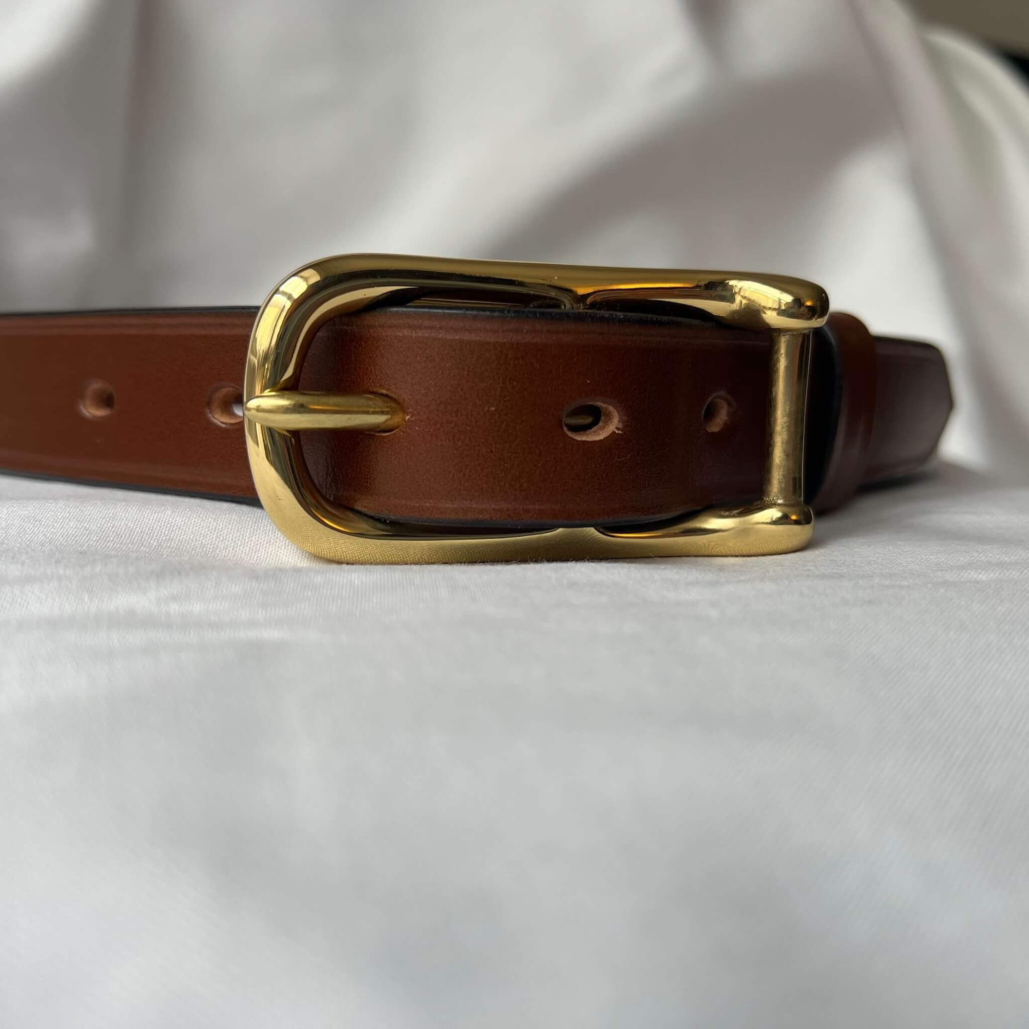 close up of ladies' skinny leather belt with solid sand cast brass buckle