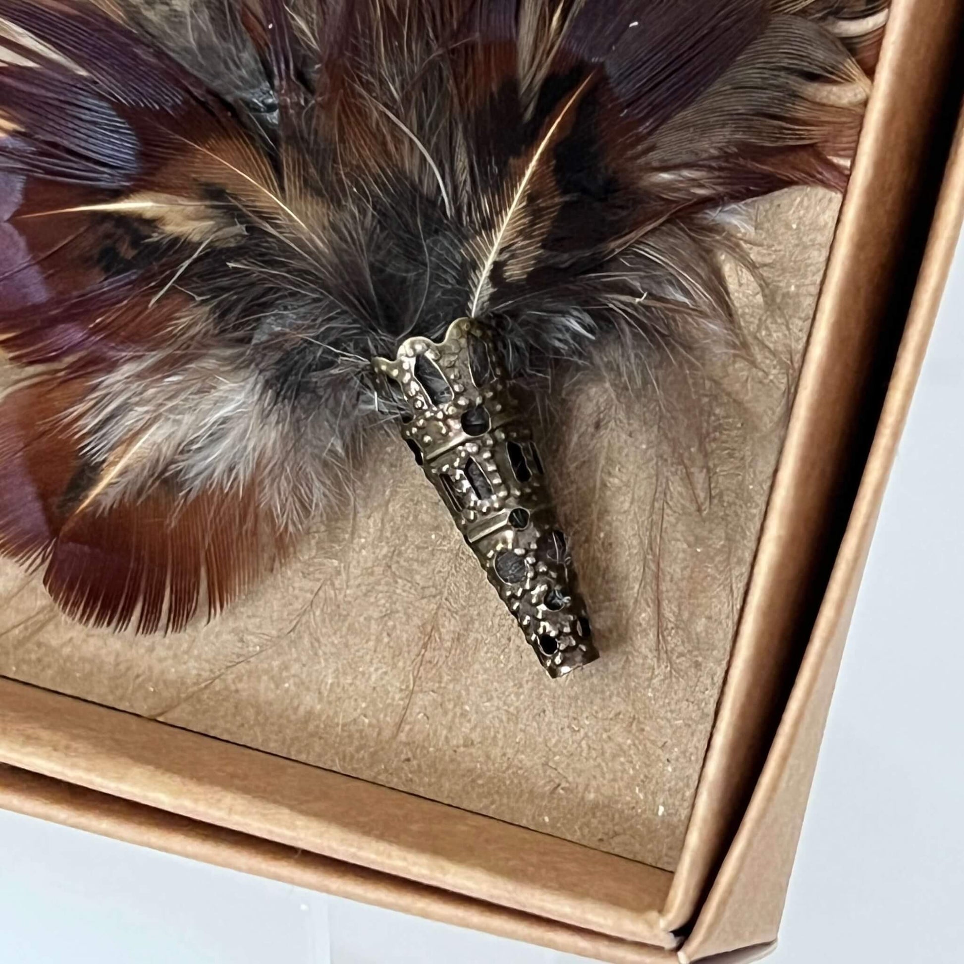 close up of small feather brooch pin showing decorative tip