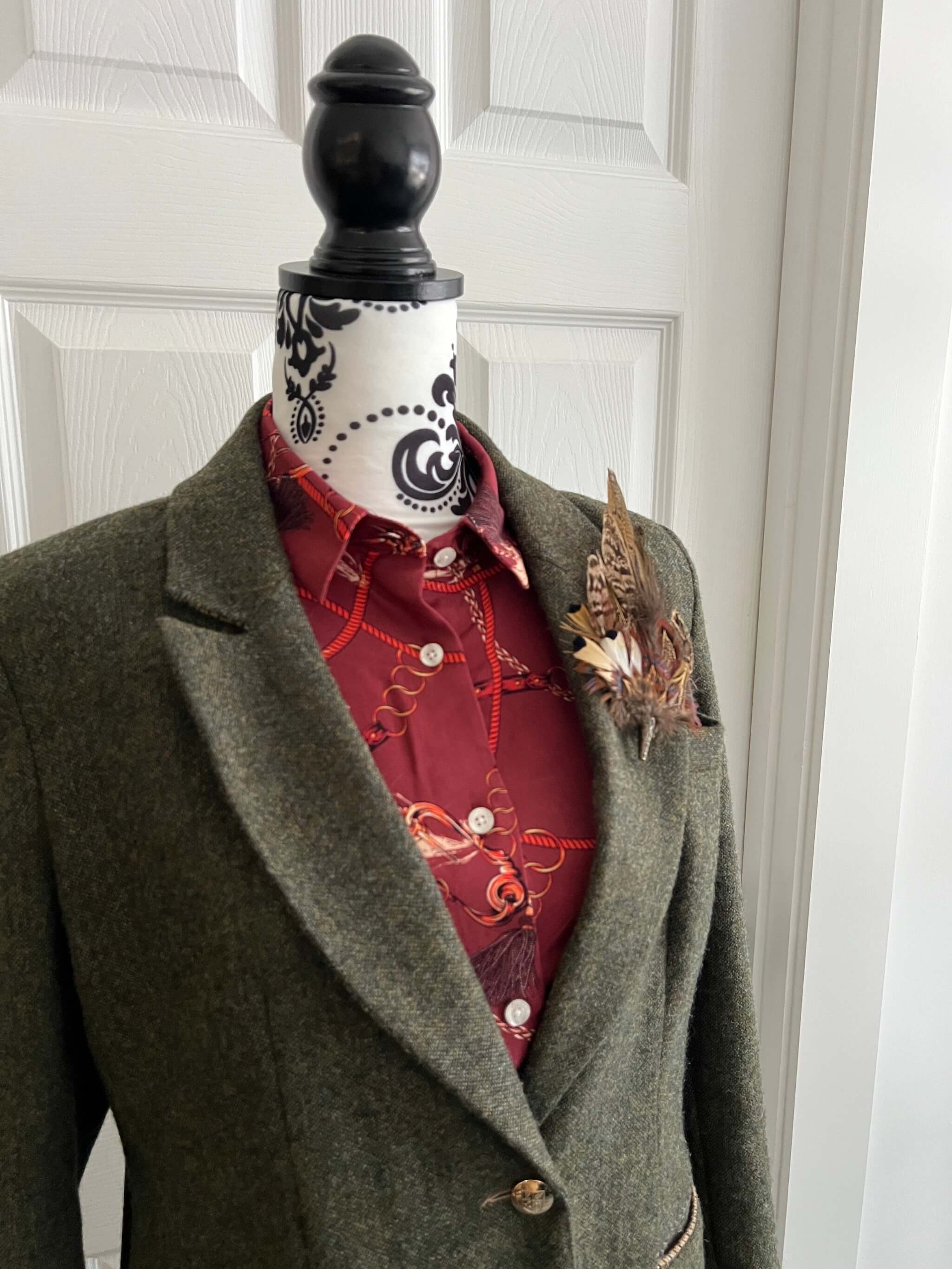 country outfit showing green tweed jacket and feather brooch pin